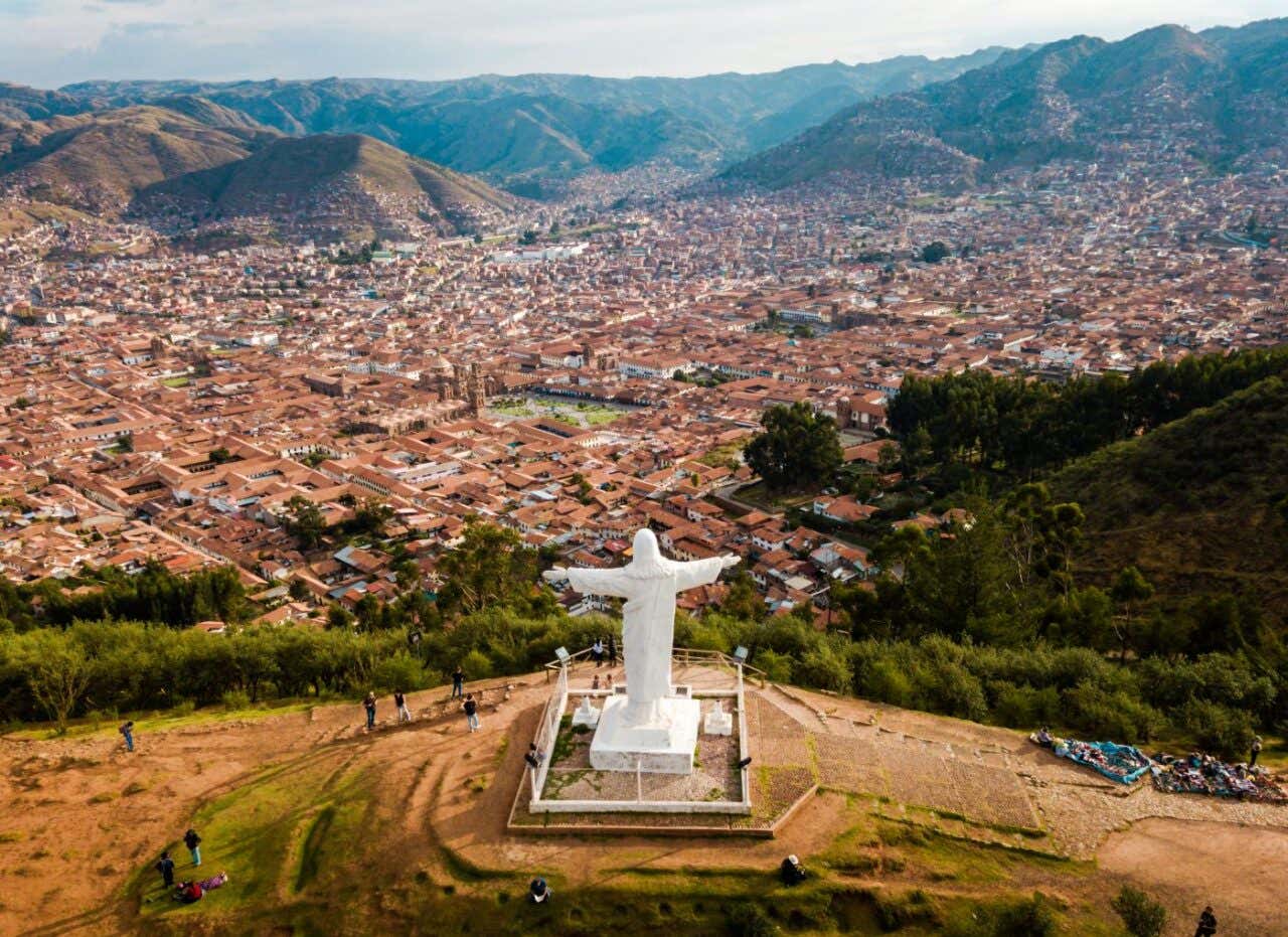 Un mirador donde se aprecia una estatua de Cristo con la ciudad de Cusco al fondo
