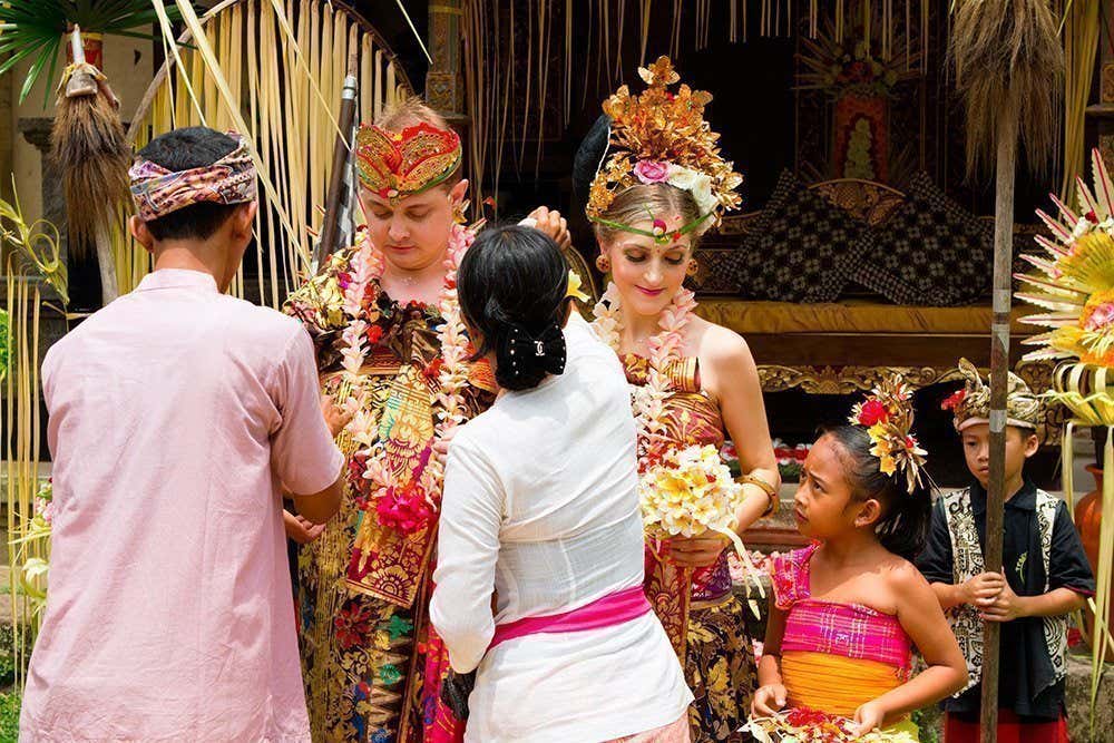 Deux personnes portant les vêtement traditionnels des mariages de Bali