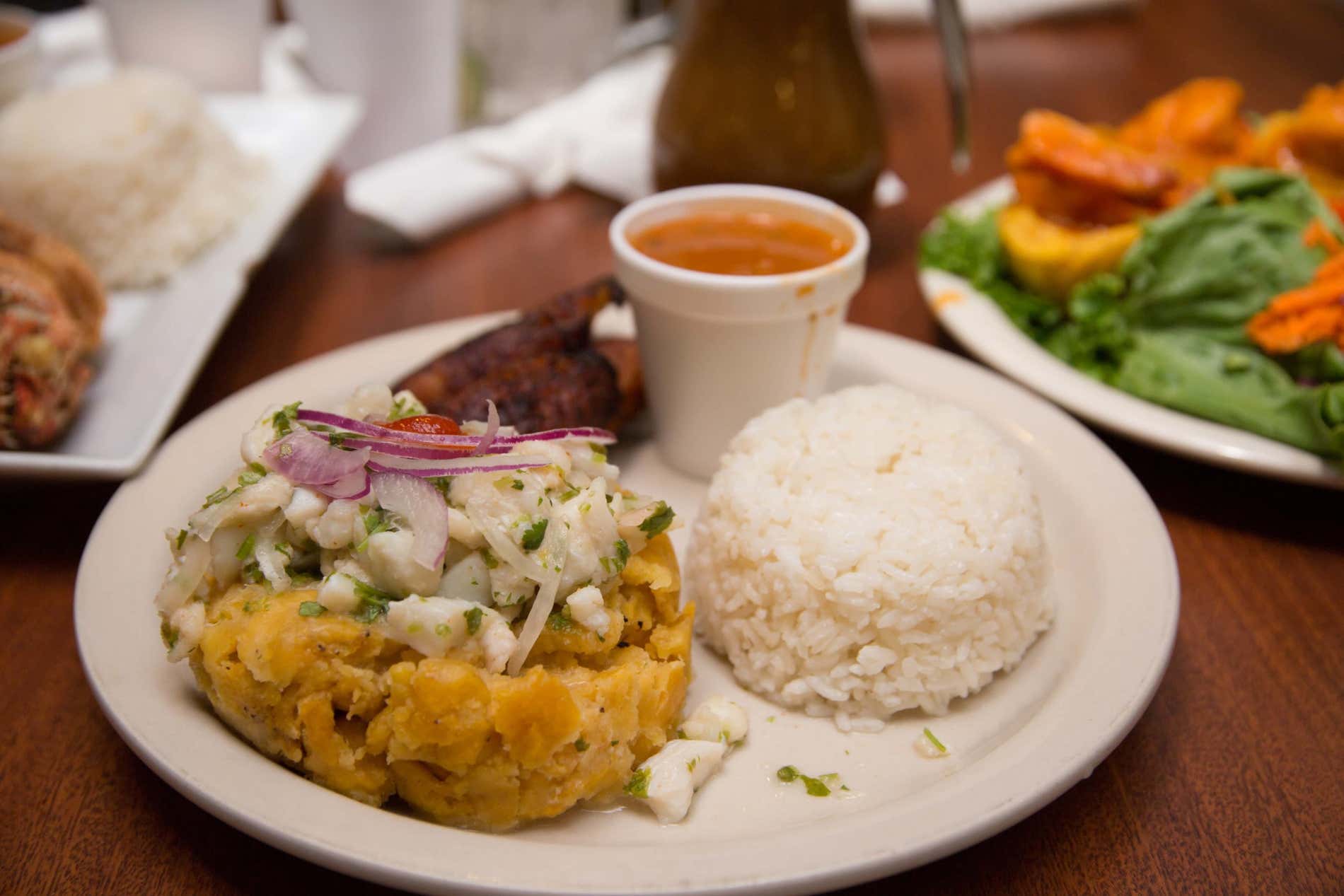 El mofongo típico de Puerto Rico acompañado de arroz y salsa.