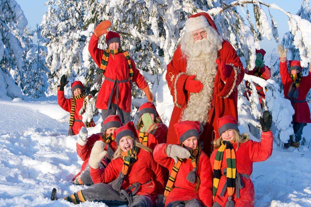 Papá Noel junto a niños disfrazados de duendes en la Laponia Finlandesa