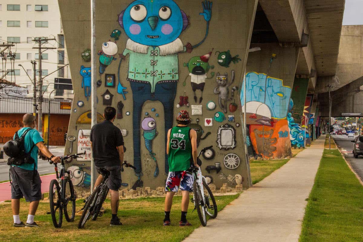 Photo Musée d’Art urbain à ciel ouvert de Sao Paulo. Touriste à vélo admirant les graffitis.