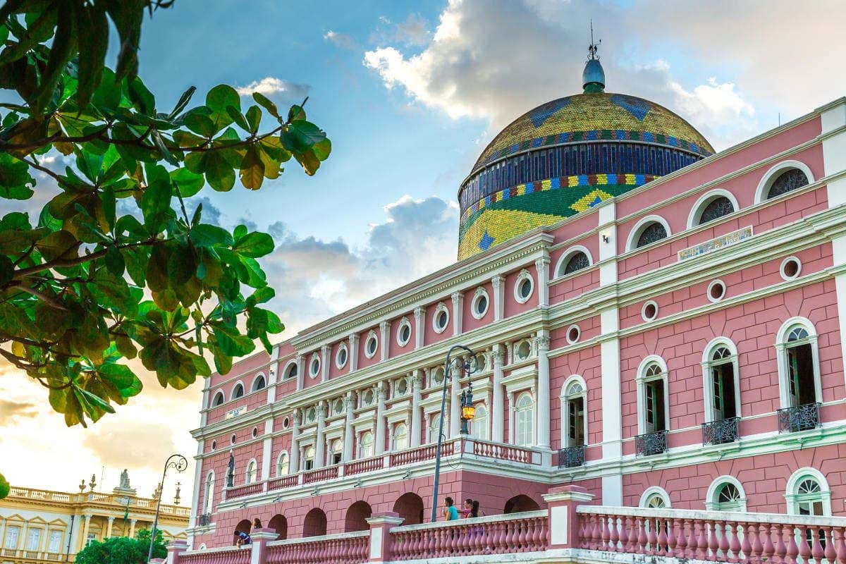 Fachada do Teatro Amazonas rosa com uma grande cúpula colorida com as cores do Brasil, um excelente exemplo da diversa arquitetura no Brasil