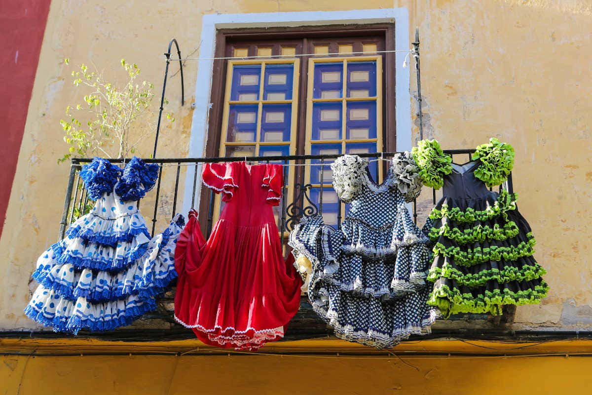 Cuatro trajes de flamenca colgados en un balcón