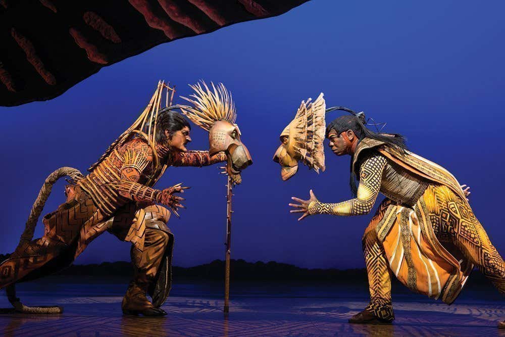 Due attori del musical Il re Leone di New York, vestiti da leoni, si guardano con fare minaccioso sul palco
