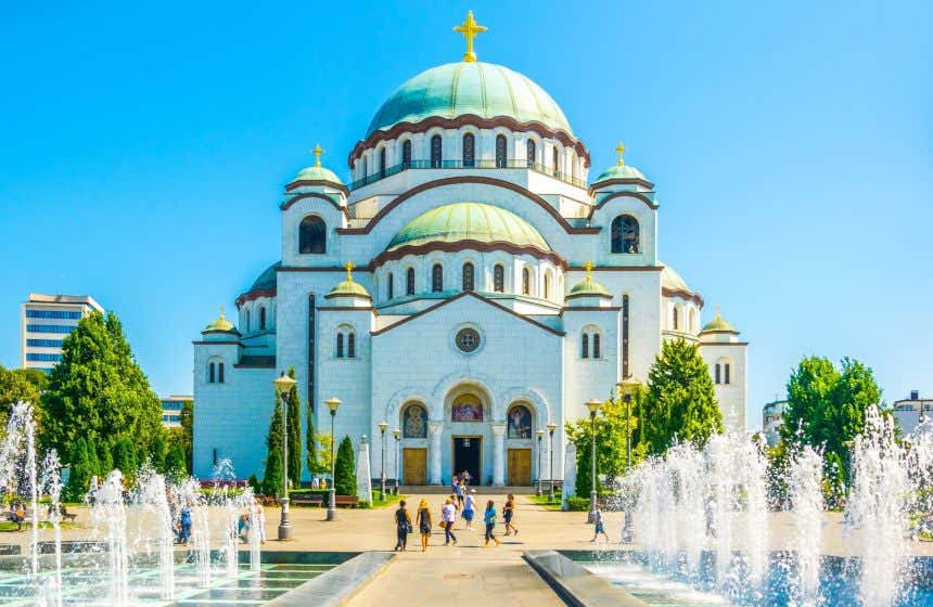 Panorâmica da fachada do templo de São Sava em Belgrado, com turistas na paisagem