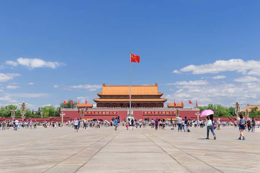 Mausoléu de Mao na Praça de Tian'anmen em Pequim com diversos visitantes em um dia de sol
