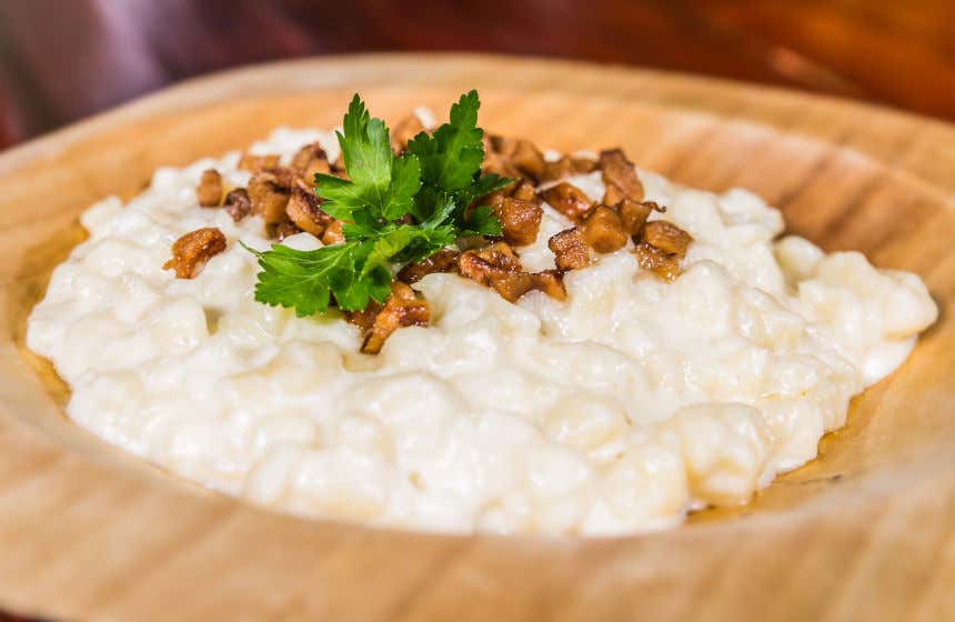Prato de bryndzové halušky, com batatas e toucinho frito