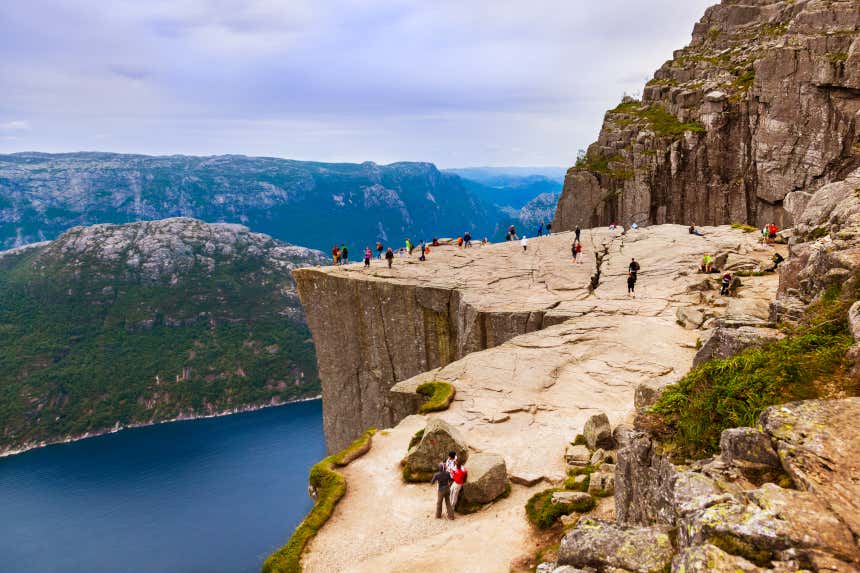 Um grupo de pessoas apreciando a paisagem do mirante do Púlpito, no fiorde Lysefjord