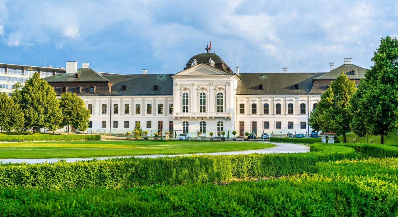 Panorámica del Palacio Grassalkovich con las nubes de fondo y los jardines verdes en primer plano