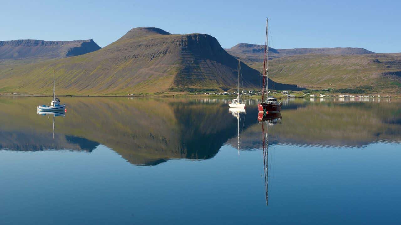 Bateaux dans la baie d'Ísafjörður avec des collines en arrière plan