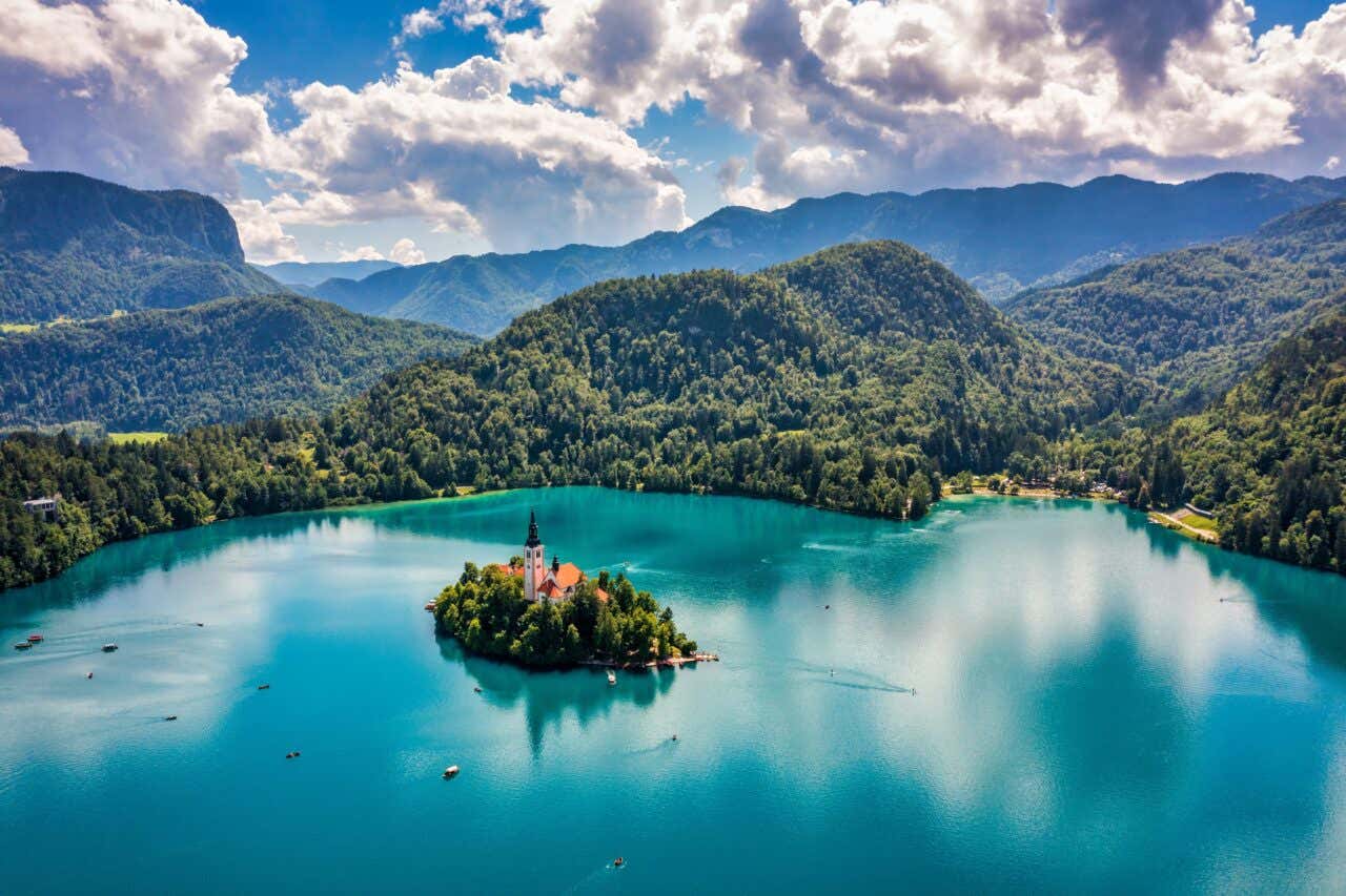 Le lac de Bled d'un bleu intense, avec son île et son église et des collines couvertes de végétation en fond