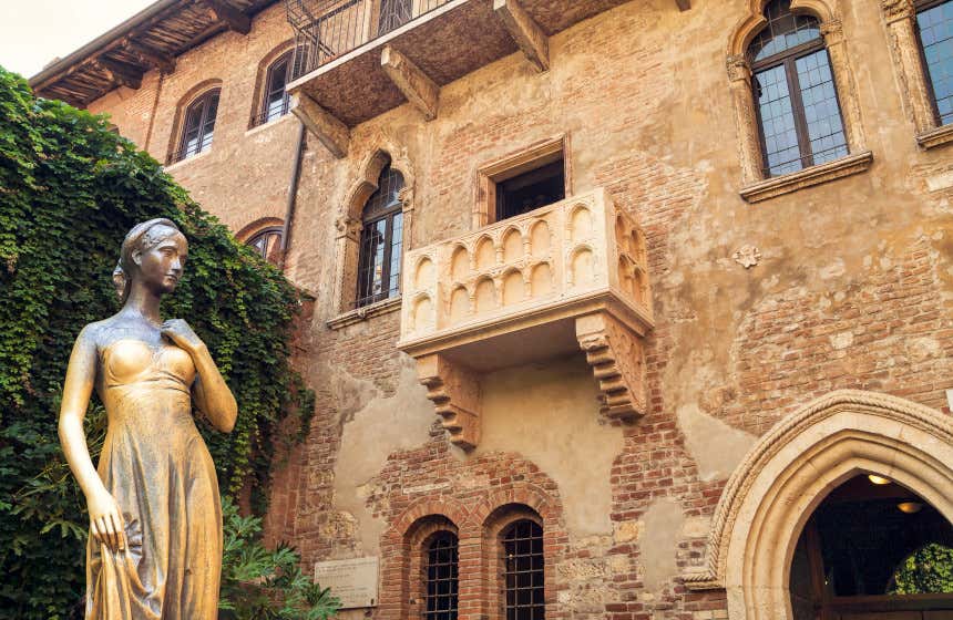 Fachada da casa de Julieta em Verona com uma escultura em primeiro plano