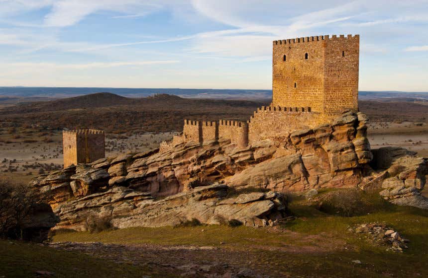 El castillo de Zafra sobre una colina rocosa y un paisaje sin edificios al fondo.