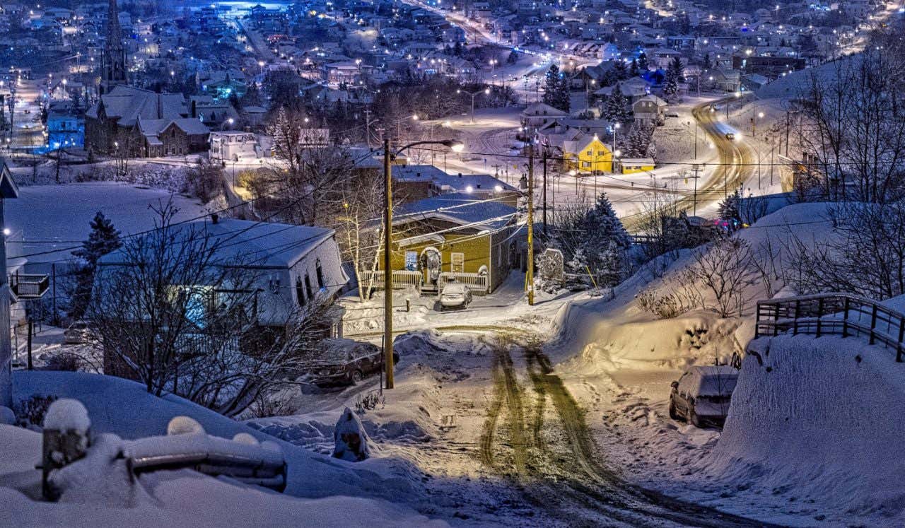 Vista panorámica nocturna de las calles desiertas y nevadas de Saguenay