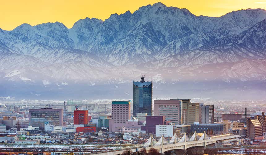Vista panorámica de Toyama, en Japón, con una cordillera de montañas nevadas a sus espaldas
