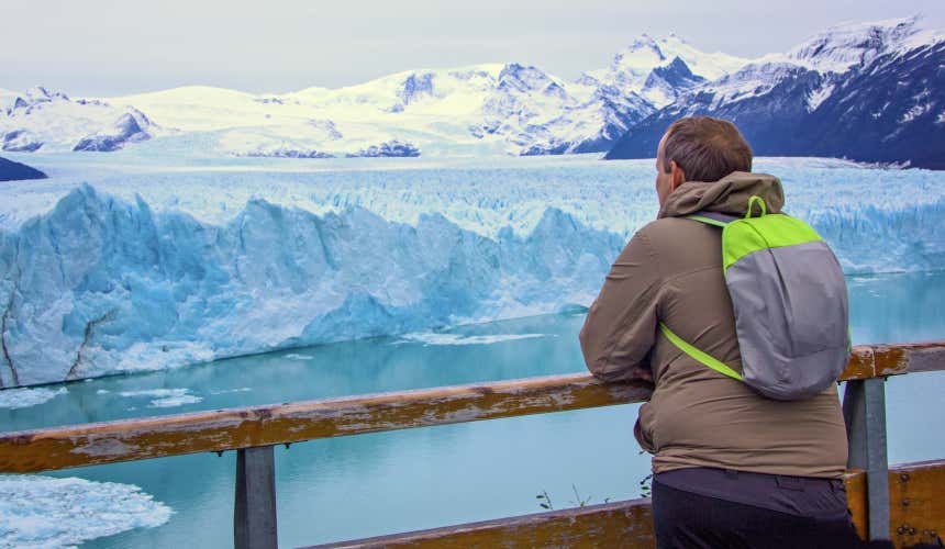 Homem de costas contemplando os blocos de gelo no Parque Nacional de Los Glaciares
