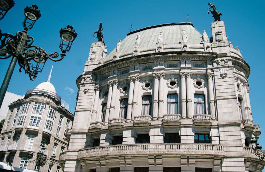 Vista frontal del teatro García Barbón en Vigo, con un edificio y una farola a la izquierda.
