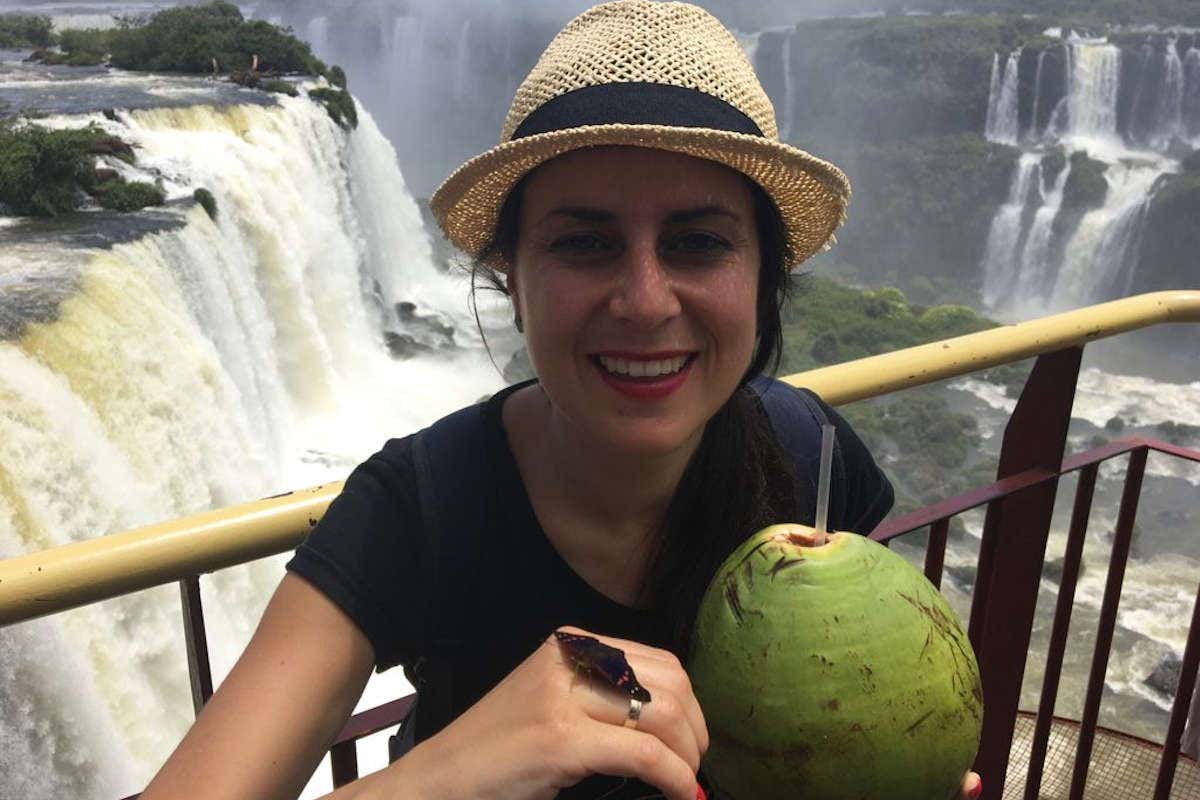 Marlene con una mariposa en la mano y tomándose un coco en las Cataratas de Iguazú