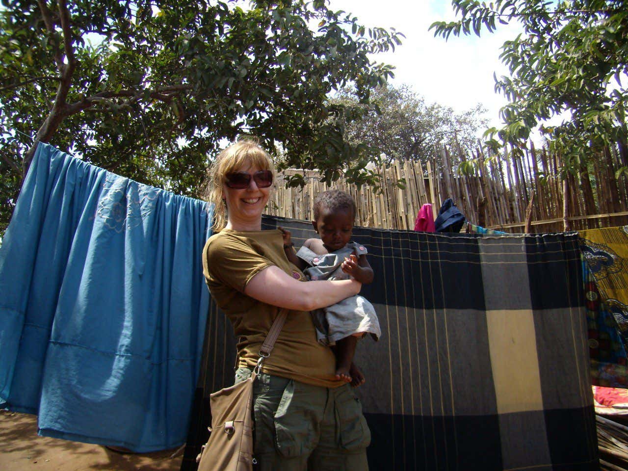Raquel cogiendo en brazos a un niño durante el voluntariado en Mozambique