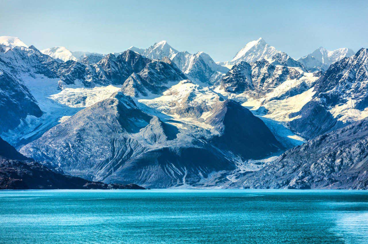 Landscape view of ice and snow covered mountain tops in Glacier Bay National Park and Preserve, one of the many places to see in Alaska