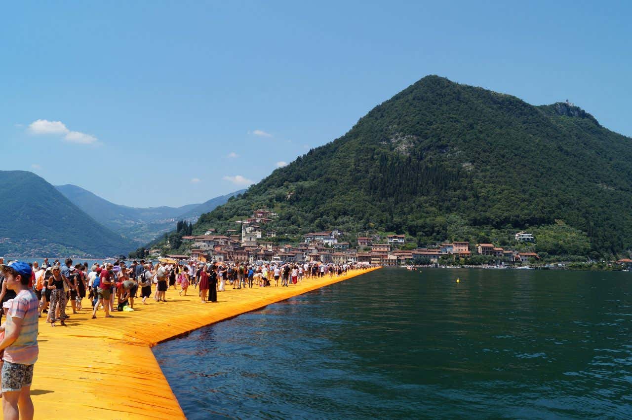 Lago d'Iseo con la sua passerella su cui transitano numerosi turisti.