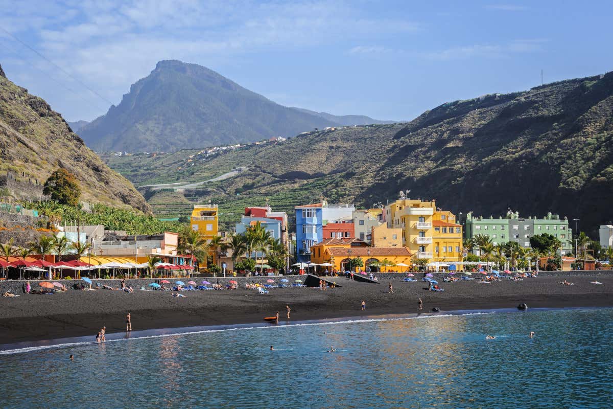 Casas de colores rodeadas de montañas y frente a una playa de Tazacorte, una de las típicas bahías de arena negra de La Palma.