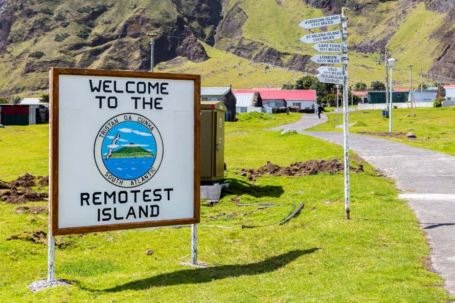 The welcome sign to Tristan da Cunha Island surrounded by green grass and mountains