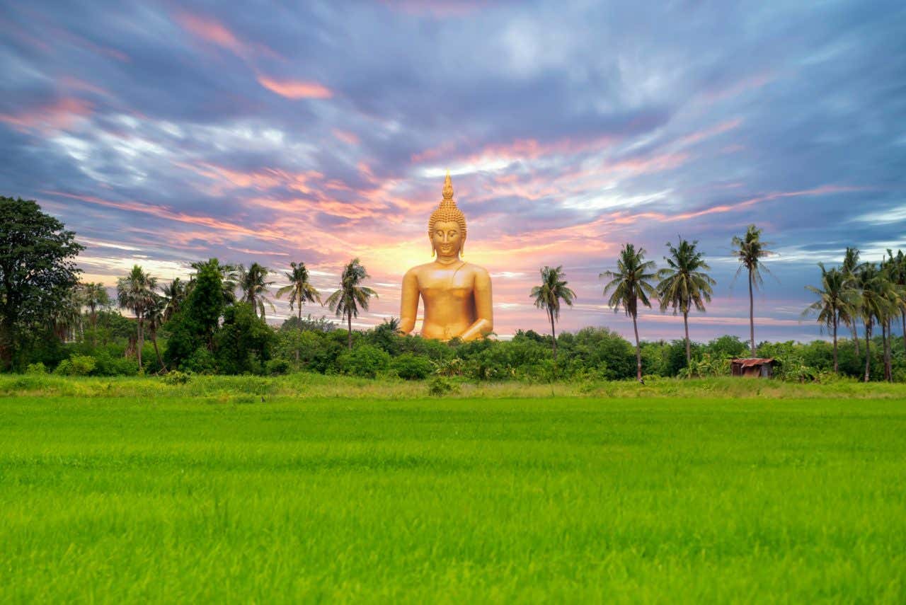 Vistas do Grande Buda da Tailândia, uma enorme estátua dourada rodeada de vegetação