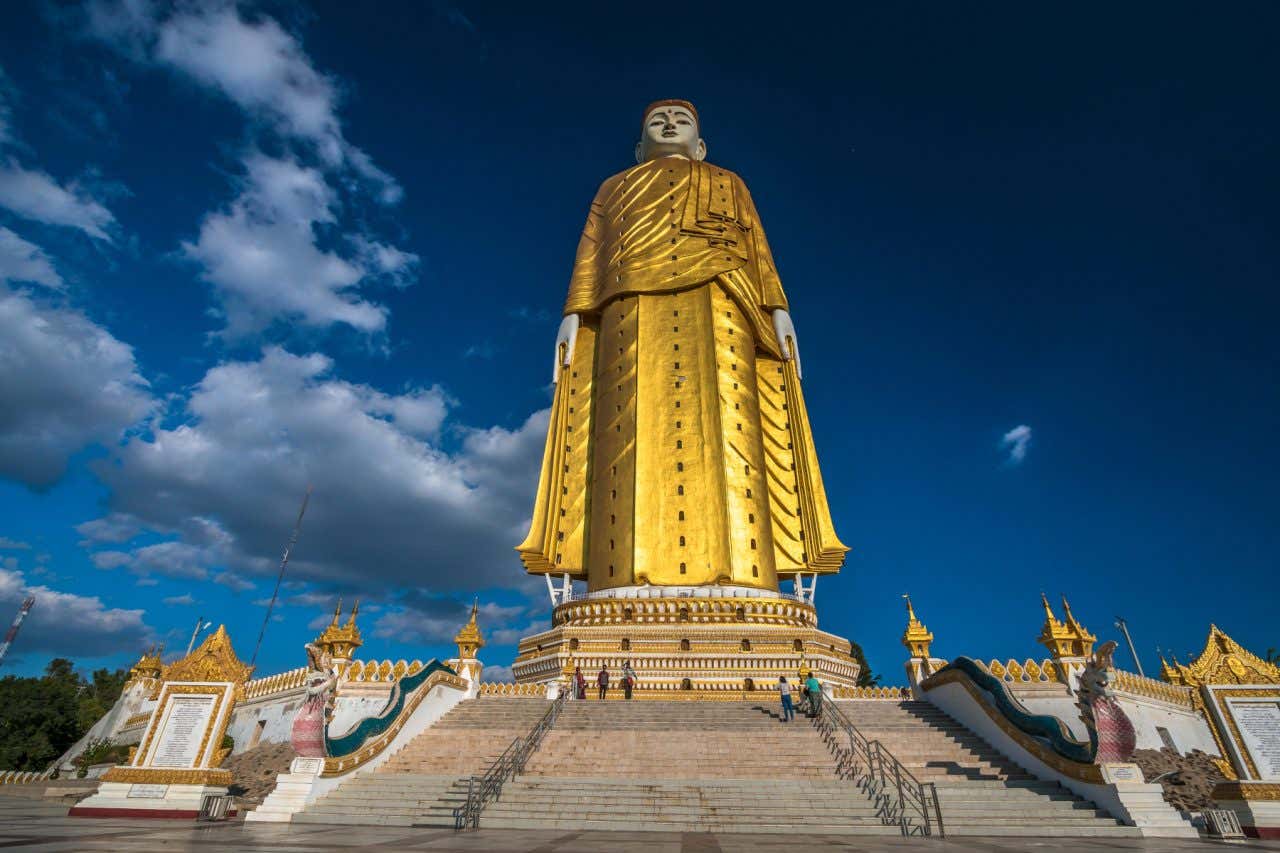 Estátua Laykyun Sekkya em Myanmar que mostra Sidarta Gautama com roupas douradas em um trono