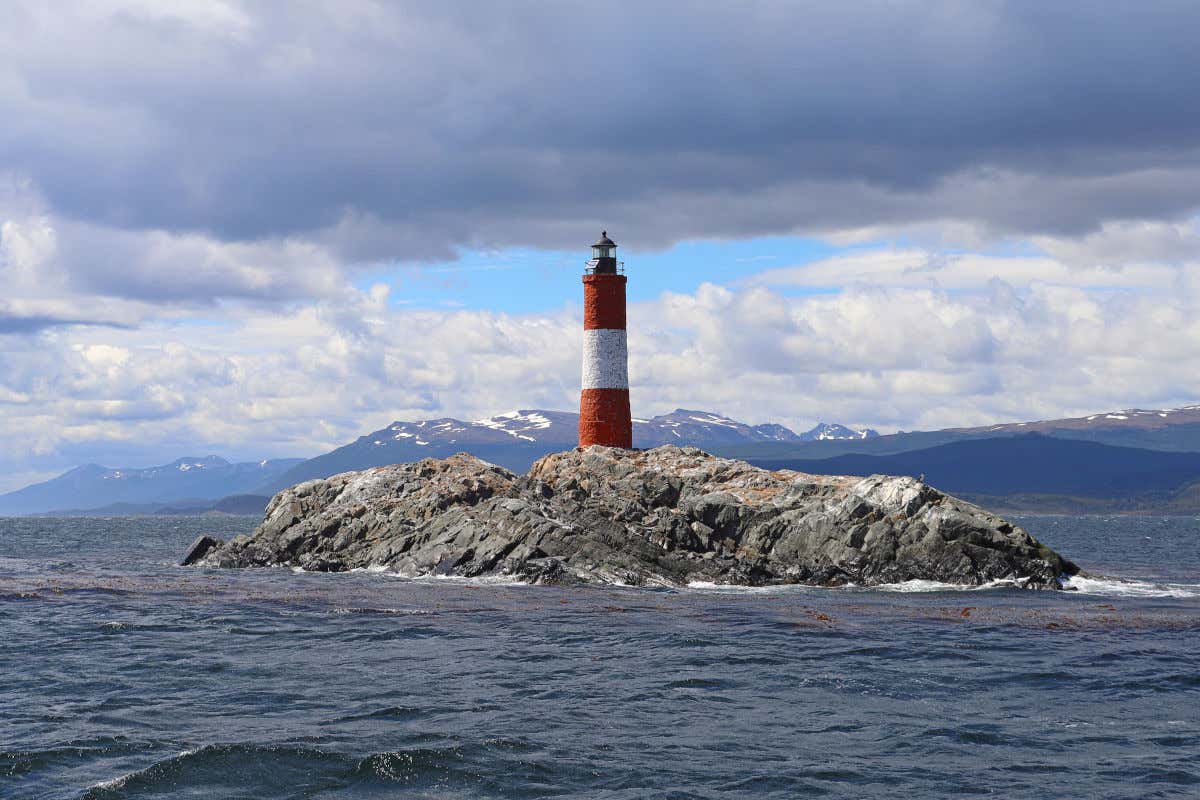 Farol do Fim do Mundo, no meio do oceano em frente às montanhas patagônicas do Chile