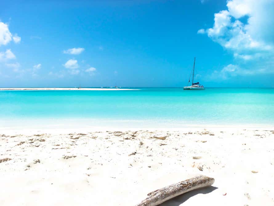 Praia Mal Tiempo com água de tom azul e uma embarcação