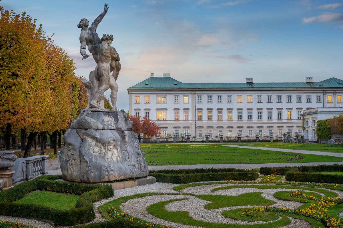 Uma escultura barroca nos jardins do palácio de Mirabell ao entardecer, em Salzburgo
