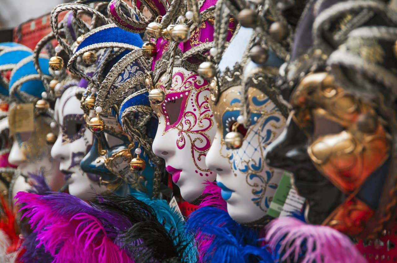 Various intricate masks of pink, blue, black, and gold.