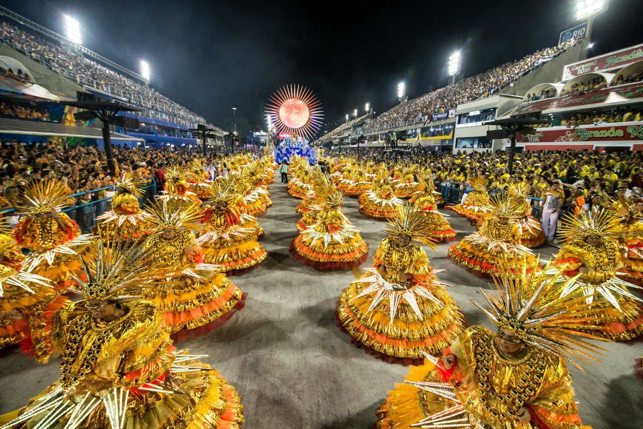 Panoramic view of Carnaval celebrations in Rio with street full of dancers dressed in golden yellow costumes