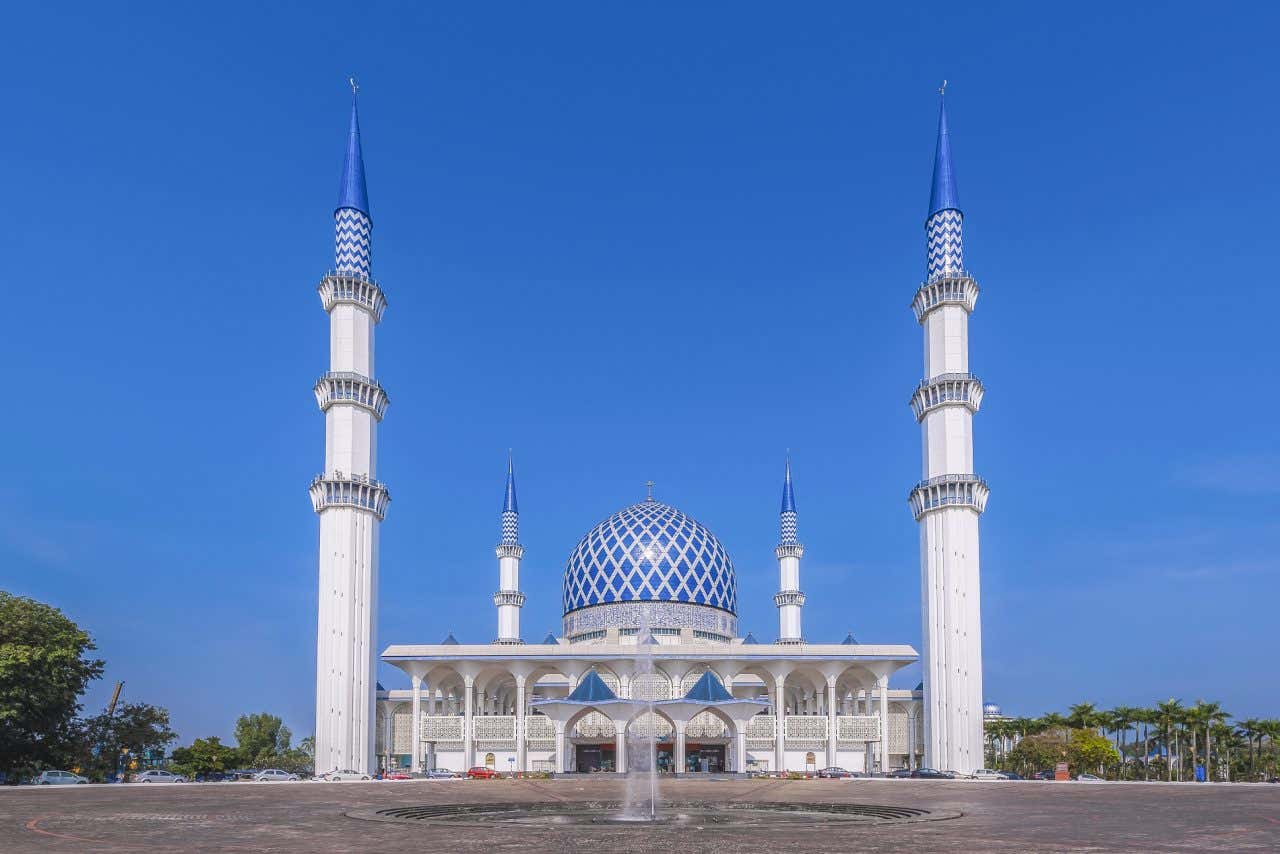 Panorâmica da mesquita Sultão Salahuddin Abdul Aziz com suas formas poliédricas e tons brancos e azuis