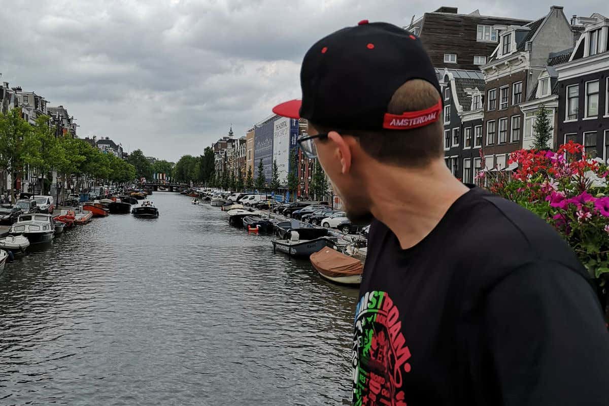 Ivan Gómez, de espaldas a la cámara, contemplando uno de los canales de Ámsterdam en un día nublado.