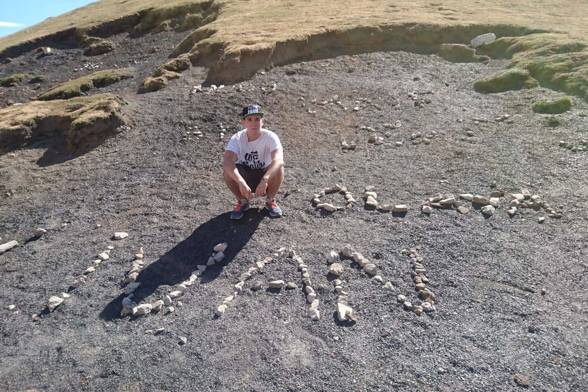 Iván Gómez junto a unas piedras que forman su nombre en los Picos de Europa, Cantabria.