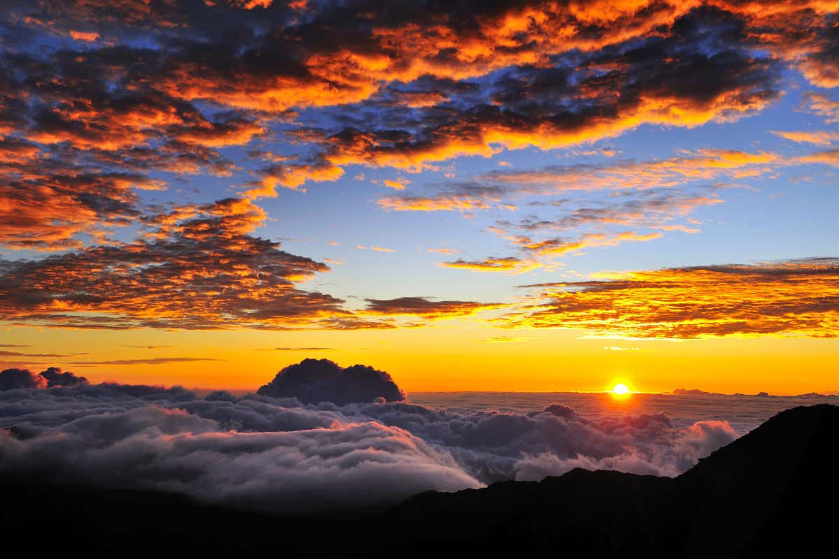 Amanhecer do alto do Parque Nacional de Haleakala com o típico mar de nuvens e o sol no horizonte