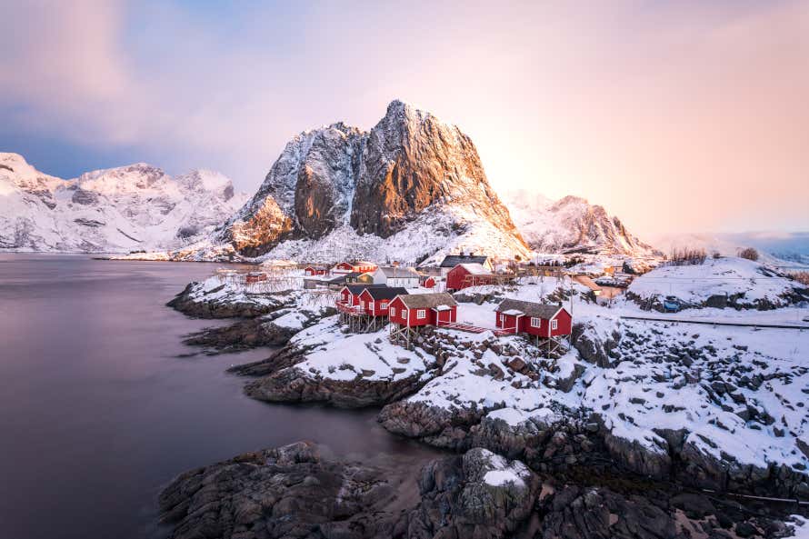 Casas vermelhas rodeadas por neve nas Ilhas Lofoten