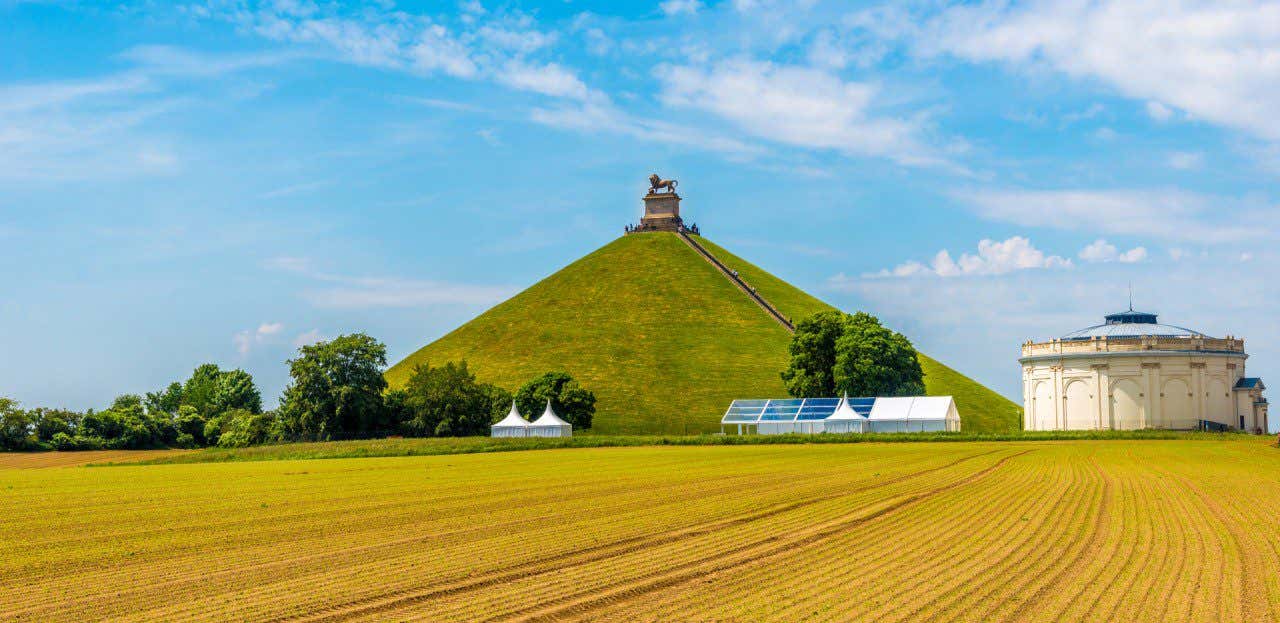 Mémorial de la bataille de Waterloo, entouré d'un champ jaune avec un ciel dégagé en Belgique