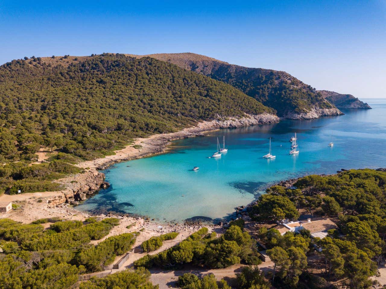 Barcos nas águas tranquilas de Cala Agulla