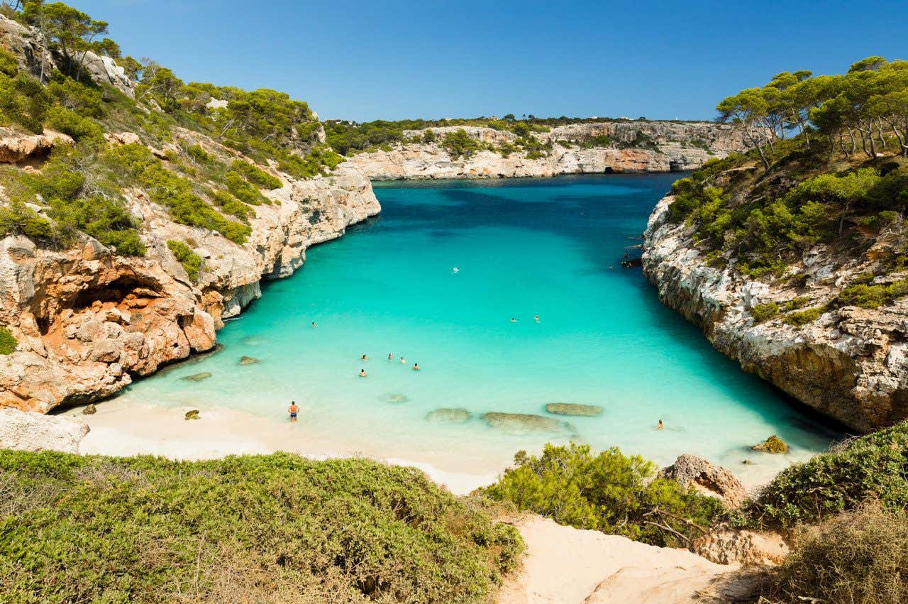 Águas turquesas que parecem uma piscina em Cala del Moro, uma praia situada entre as rochas