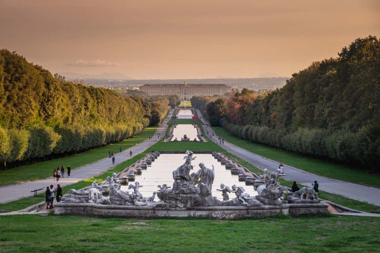 Jardins e fontes com o Palácio Real de Caserta, um dos palácios mais belos do mundo, ao fundo em um fim de tarde