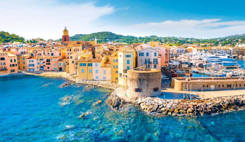 An aerial shot of Saint-Tropez, with a view of bright blue waters and colourfui buildings