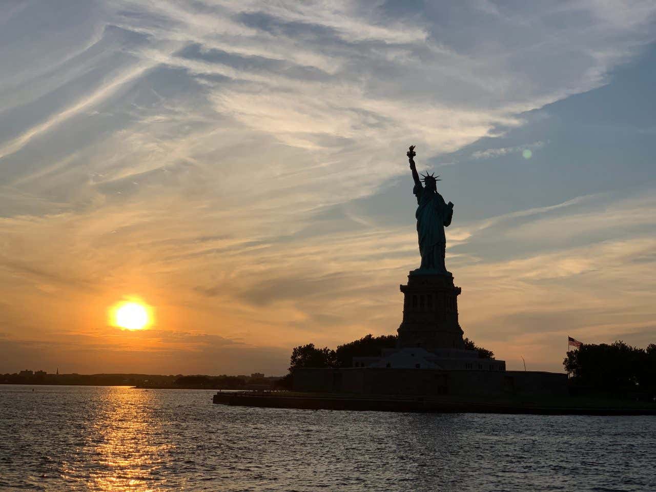 Estatua de la Libertad con el sol de fondo