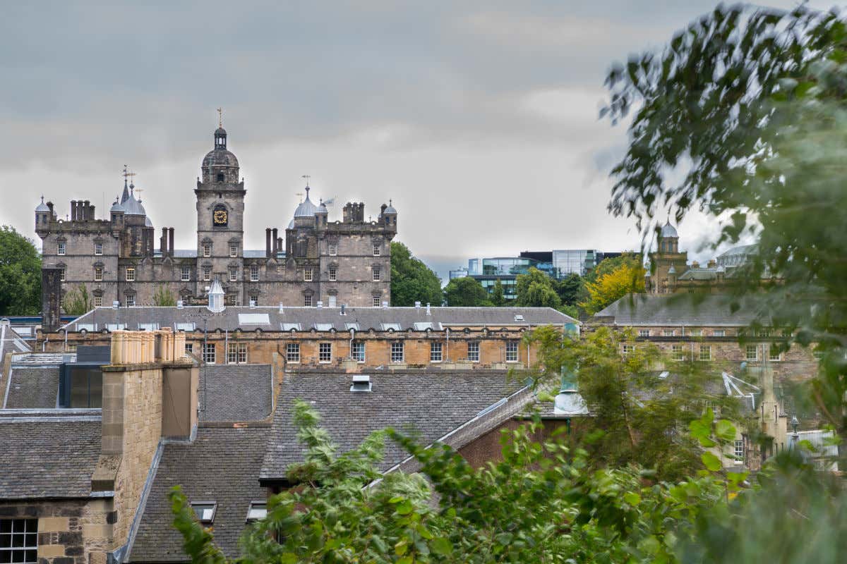George Heriot’s School, com sua torre de relógio, entre diferentes telhados do centro histórico de Edimburgo em um dia com muitas nuvens, outro lugar parte da rota de Harry Potter pela Escócia