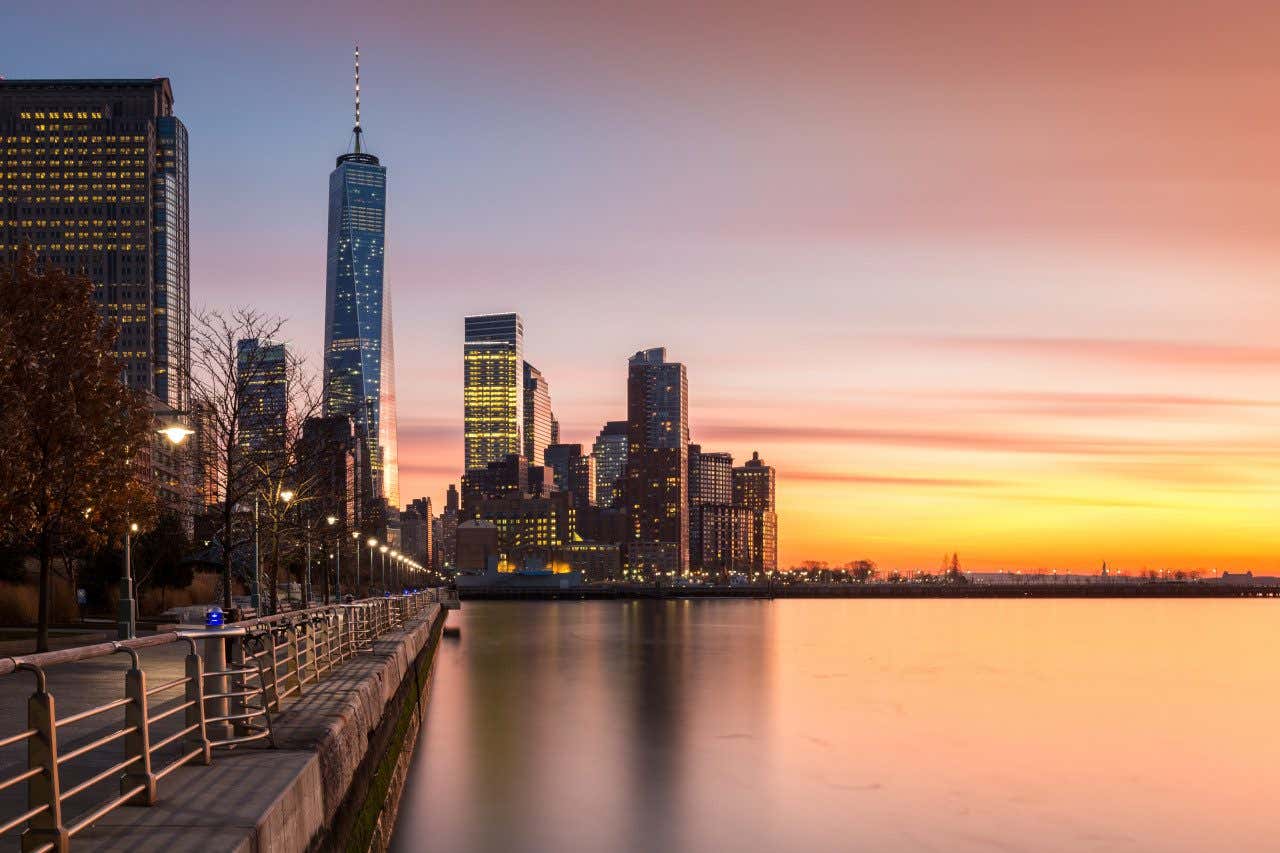 Ciel orangé depuis le Hudson River Park avec des gratte-ciels en fond