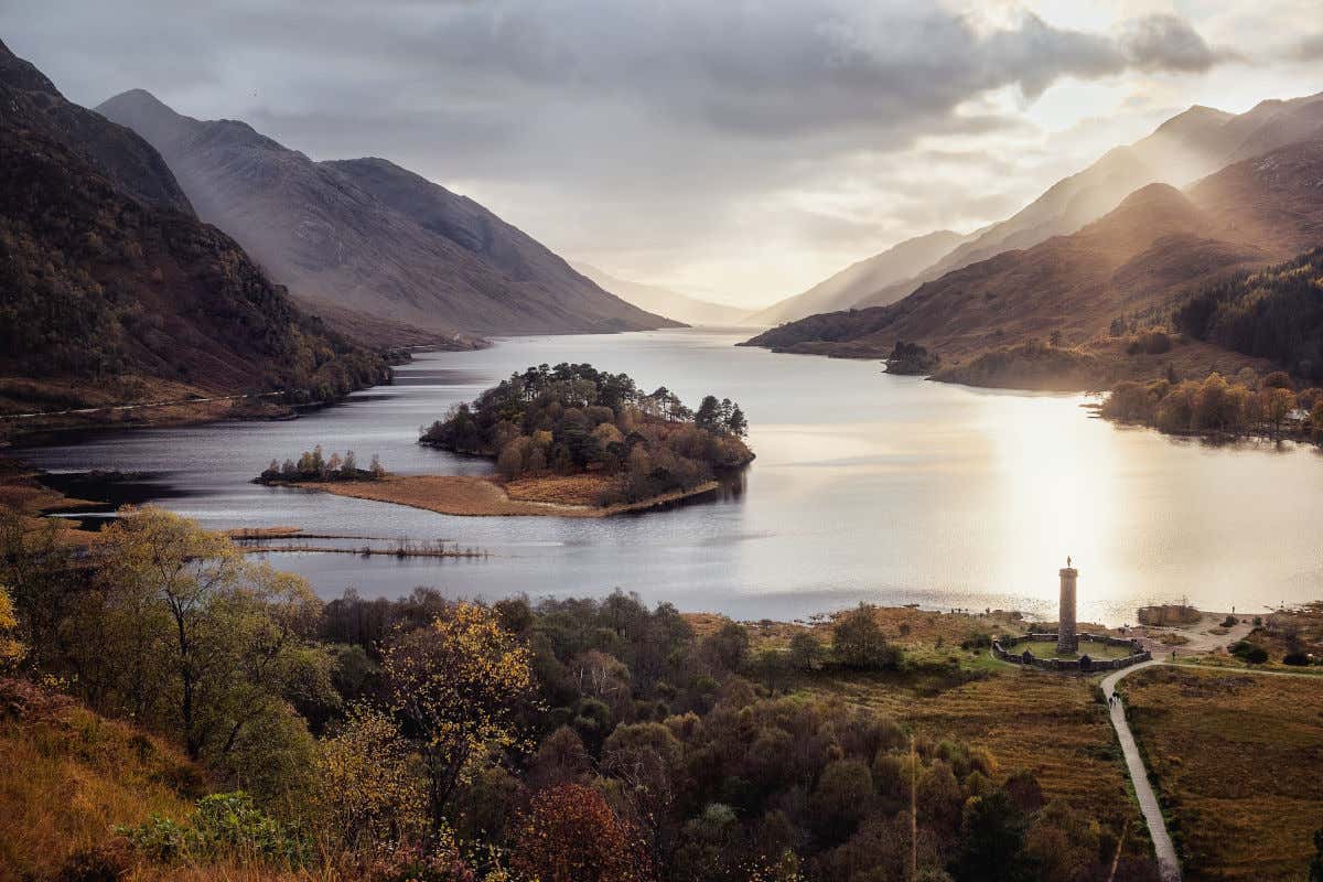 O lago Loch Shiel da Escócia ao entardecer com a névoa começando a atravessar suas montanhas