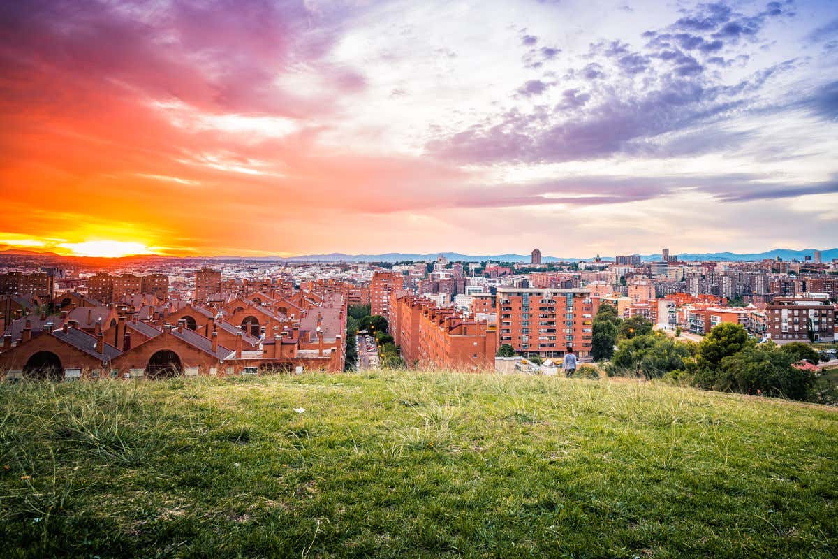 Mirador del cerro del Tío Pío, un lugar mágico para ver atardecer en Madrid. Se puede divisar en la imagen varios edificios residenciales mientras el sol se oculta en el horizonte.