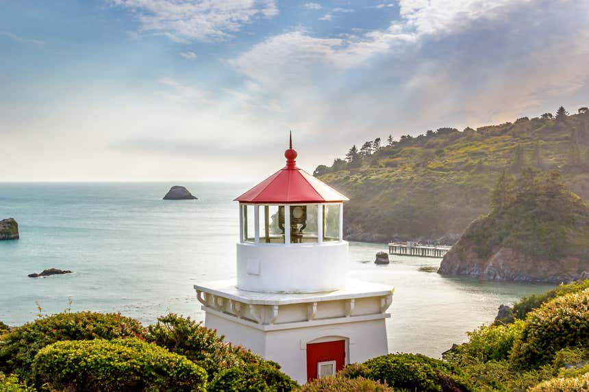 Trinidad Lighthouse, com o topo avermelhado, e a baía Trinidad ao fundo